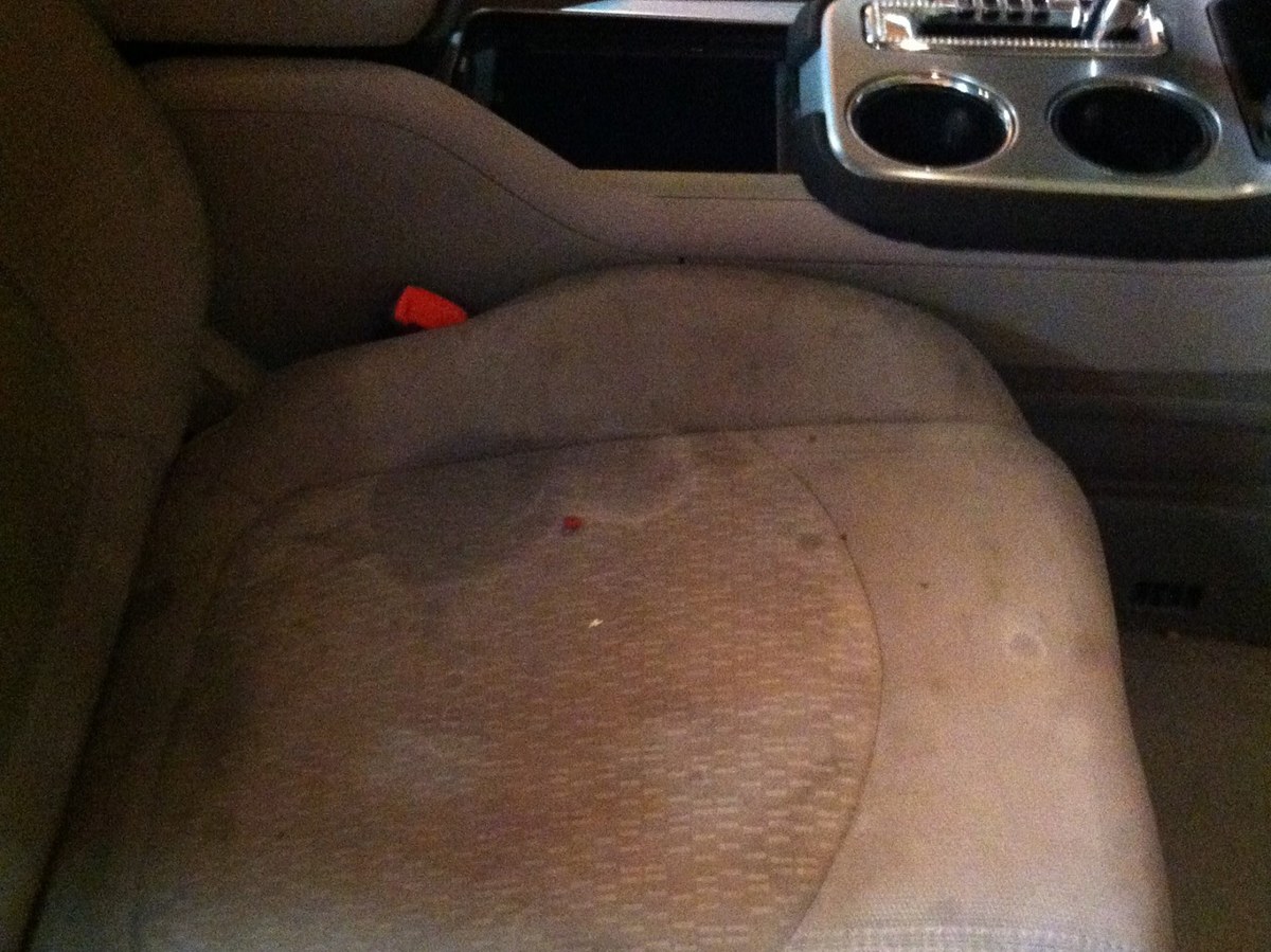Dirty stained fabric car seat before deep cleaning
